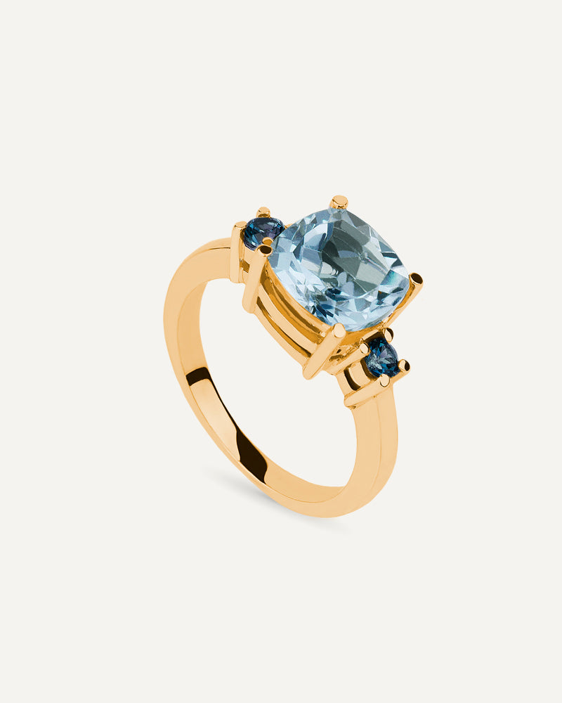 Anillo Luxe en plata de ley con baño de oro con topacio azul Sky talla cushion.