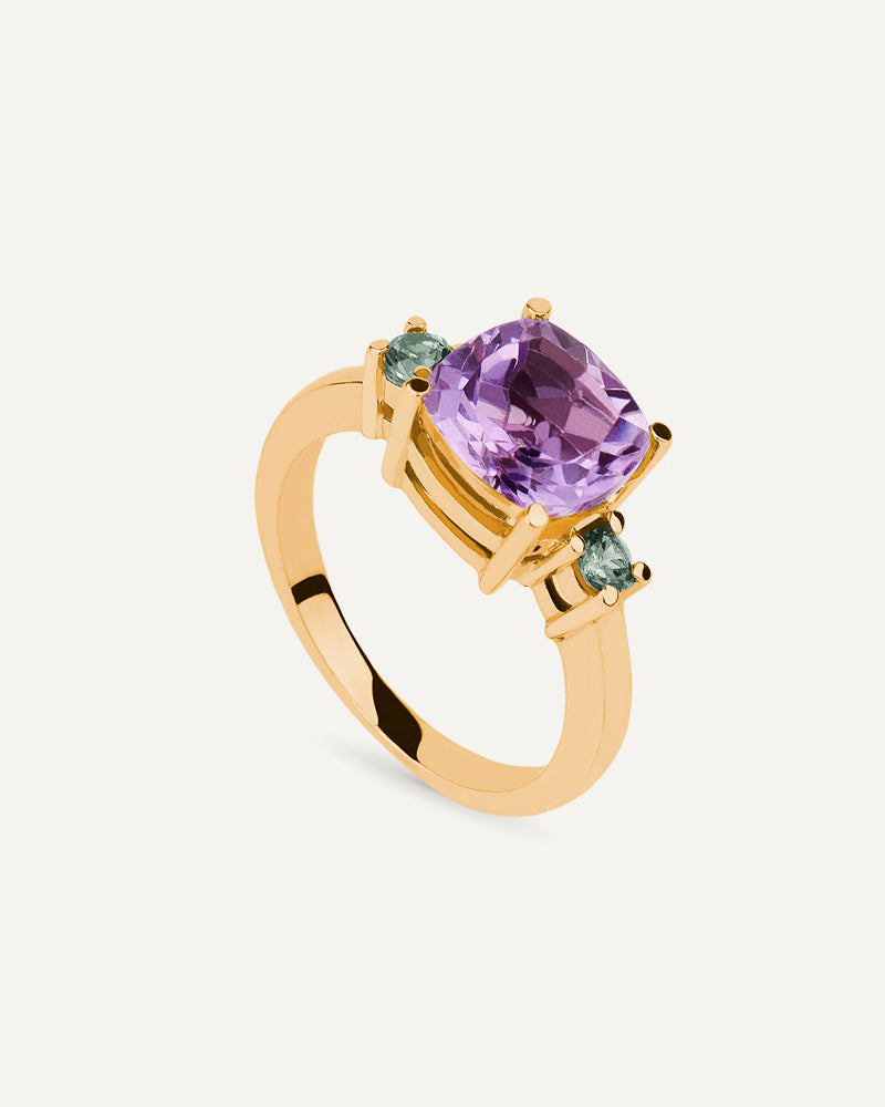 Anillo Luxe en plata de ley con baño de oro y con amatista en talla cushion y amatistas verdes en talla redonda a ambos lados.