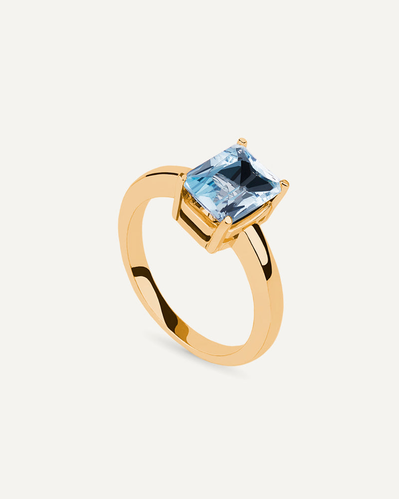 Anillo Luxe en plata de ley con baño de oro y con topacio azul Sky en talla octogonal.