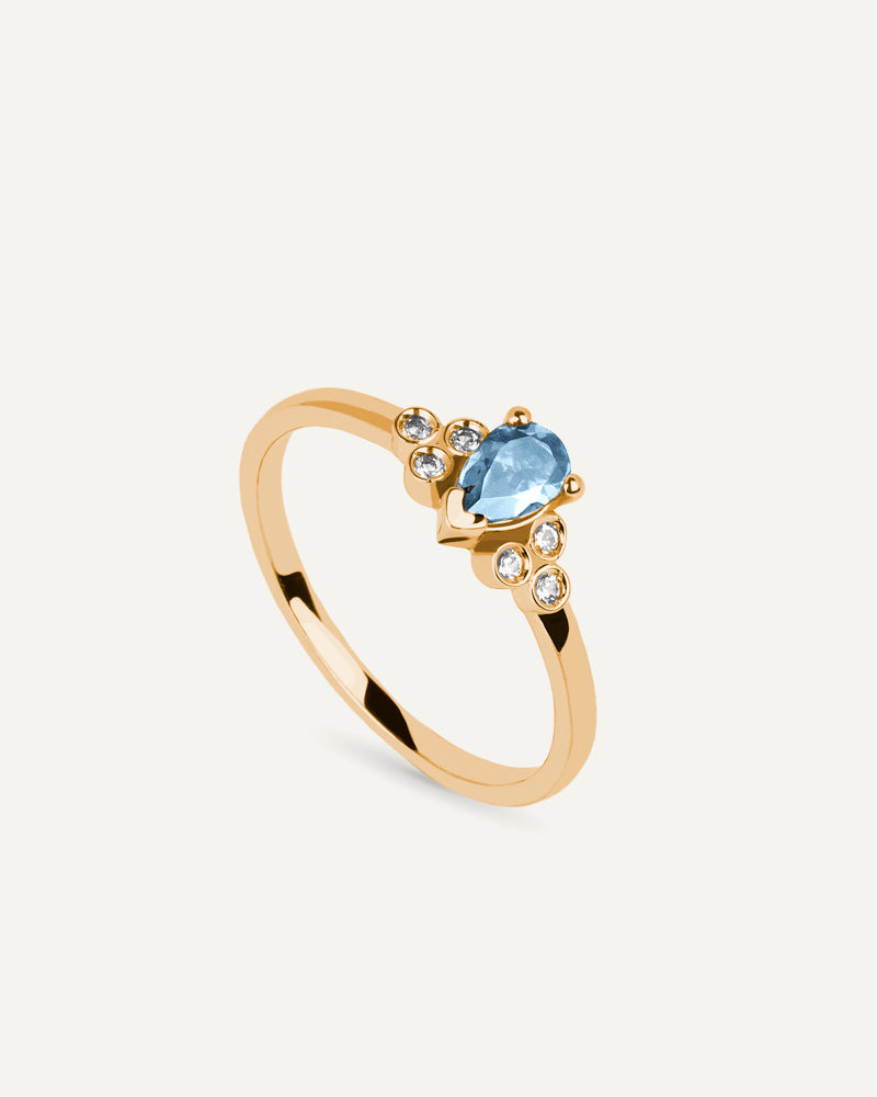 Anillo Petite en plata de ley con baño de oro y con topacio Sky en talla perilla y topacios blancos.