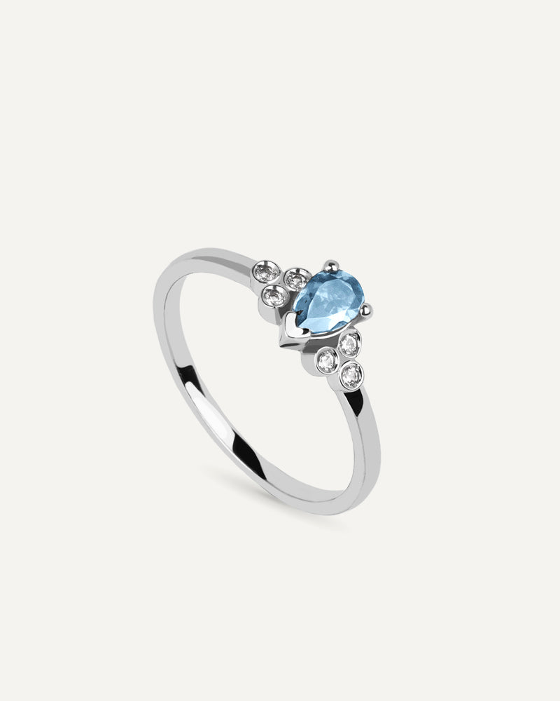 Anillo Petite en plata de ley con topacio Sky en talla perilla y topacios blancos.